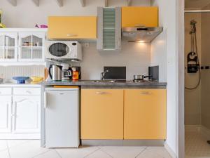La cuisine est équipée de placards jaunes et d'un réfrigérateur blanc. dans l'établissement Holiday Home La Plage by Interhome, à Surville
