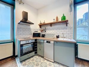 a kitchen with a stove and a sink at La Suite Shelby Brive in Brive-la-Gaillarde