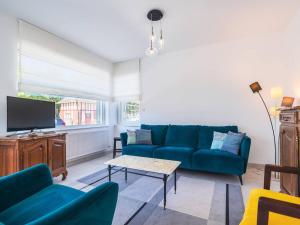 a living room with a blue couch and a tv at Charmante Maison à Quentovic, 3 Chambres - FR-1-821-21 in Le Touquet-Paris-Plage