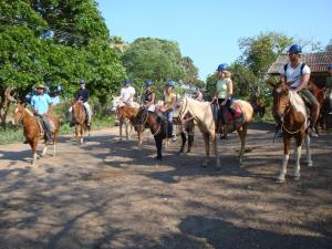 a group of people riding horses on a dirt road at Pousada & Camping Santa Clara in Santa Helena