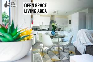 an open space living area with a table and chairs in a kitchen at 2 Bedroom Apartment By Littlepiggyrentals Short Lets & Serviced Accommodation Peterborough With Fast Wi-Fi & Free Parking in Peterborough