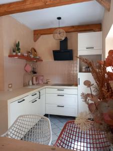 a kitchen with white cabinets and a table and chairs at 2 or 4-person apartment CasaDaEfde in Cingoli