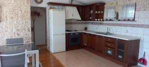 a kitchen with wooden cabinets and a white refrigerator at Blue Lagoon Apartment Platinum in Lovište