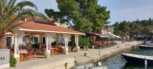 a restaurant next to a river with tables and chairs at Blue Lagoon Apartment Platinum in Lovište