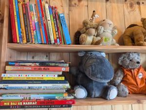 a book shelf filled with books and stuffed animals at Piecówka in Kaczkowo