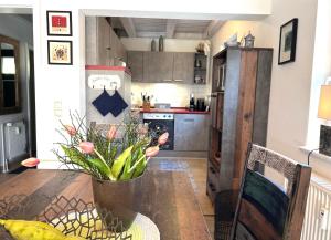 a kitchen with a table with a vase of flowers on it at Kormoran Muschelsucher in Prerow