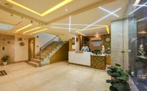 a lobby of a building with a man standing at a counter at Hotel Kuber International - New Delhi Train Station in New Delhi