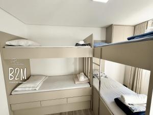 a small room with two bunk beds in it at Beto Carrero, pé na areia, piscina aquecida, Bali in Piçarras +47 photos