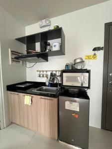 a small kitchen with a sink and a microwave at Condo in Camella Manors in Puerto Princesa in Puerto Princesa City