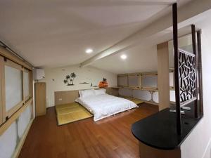 a bedroom with a bed in the middle of it at Miaoli Sanyi Travelling Homestay in Sanyi