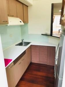 an empty kitchen with a sink and a refrigerator at Miaoli Sanyi Travelling Homestay in Sanyi