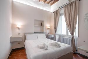 sypialnia z białym łóżkiem i ręcznikami na nim w obiekcie Ponte Vecchio Central Flats we Florencji