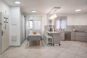 a white kitchen with a table and a counter at Sea Tower in H̱adera