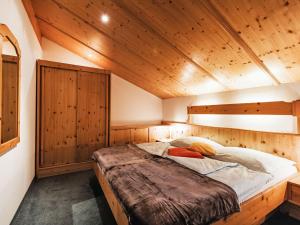 Un dormitorio con una cama en una cabaña de madera. en Apartment Tuenta by Interhome, en Dienten am Hochkönig