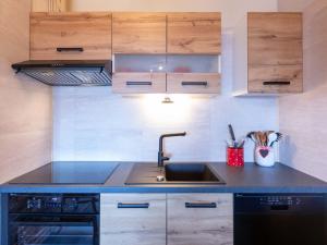 a kitchen with a sink and wooden cabinets at Apartment Villars Vacances 20 by Interhome in Villars-sur-Ollon