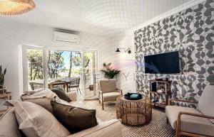a living room with a couch and a tv at Stunning beach apartment in Almancil