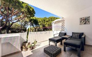a balcony with two chairs and a table and a tree at Stunning beach apartment in Almancil
