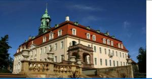 a large building with a tower on top of it at Ruhig und spartanisch Wohnen in Lichtenwalde 2 in Lichtenwalde