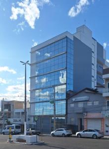 a large glass building with cars parked in front of it at Hotel Santa Rita in Santa Cruz