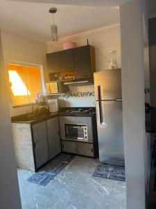 une cuisine avec une cuisinière et un réfrigérateur dans l'établissement Casa Raio de Luz, à Itanhaém