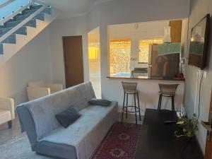 a living room with a couch and a kitchen at Casa Raio de Luz in Itanhaém