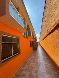 un couloir vide d'un bâtiment avec un mur orange dans l'établissement Casa Raio de Luz, à Itanhaém