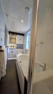 a white bathroom with a tub and a sink at Willowdale B&B in Breakish