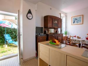 ラ・ベルヌリー・アン・レッツにあるHoliday Home Rose-May by Interhomeのテーブルと壁に時計があるキッチン