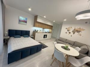 - une chambre avec un lit bleu, une table et un canapé dans l'établissement Lake View Sea Apartment Rogowo Pearl, à Rogowo