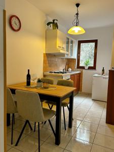 a kitchen with a wooden table with chairs and a clock at apartman MLIN 4 in Lun