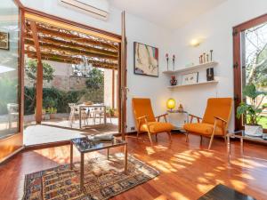 a living room with orange chairs and a table at Holiday Home Villa Chantal by Interhome in Pals