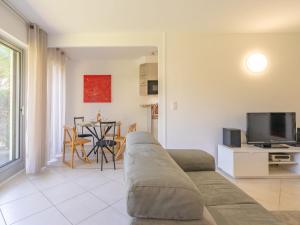 a living room with a couch and a television at Apartment Résidence de Mons by Interhome in Royan +14 photos
