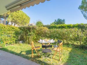 a table and chairs sitting in the grass at Apartment Résidence de Mons by Interhome in Royan