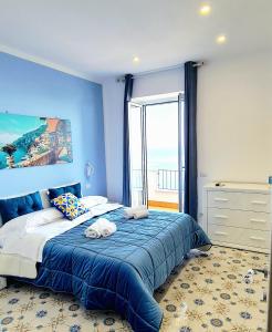 a blue bedroom with a bed with towels on it at Villa Blu Costiera in Amalfi