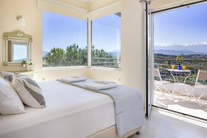 a bedroom with a bed and a large window at Villa Anatoli in Stalos +33 photos