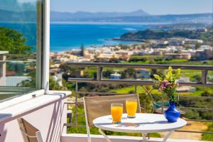 a table with two glasses of orange juice on a balcony at Villa Anatoli in Stalos