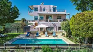 a house with a swimming pool in front of it at Villa Anatoli in Stalos