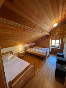 a room with two beds in a wooden cabin at Kas Alm am Grandsberg in Schwarzach