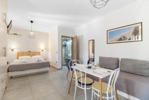 a bedroom and living room with a bed and a table at Dionysia Rooms in Lefkada
