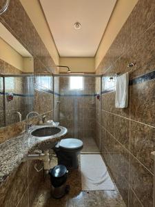 a bathroom with a toilet and a sink at Comodoro Hotel e Churrascaria in Floriano