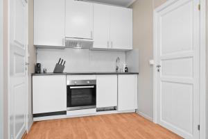 a kitchen with white cabinets and a stove at Sentral 1BR i Porsgrunn - P Apartments in Porsgrunn