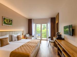 Postel nebo postele na pokoji v ubytování Movenpick Resort and Spa Fruske Terme