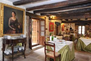 uma sala de jantar com mesas e um quadro de uma mulher em Posada La Torre de La Quintana em Liendo