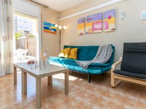 a living room with a blue couch and a table at Holiday Home Boters-2 by Interhome in Torredembarra