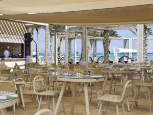 a restaurant with tables and chairs with the ocean in the background at Rixos Premium Seagate in Sharm El Sheikh
