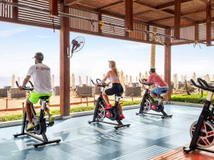 a group of people riding on exercise bikes in a gym at Rixos Premium Seagate in Sharm El Sheikh