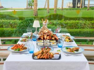 a table with plates of food on it with wine glasses at Rixos Premium Seagate in Sharm El Sheikh