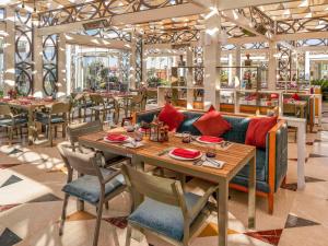 a restaurant with a couch and tables and chairs at Rixos Premium Seagate in Sharm El Sheikh