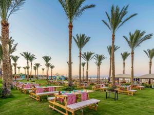 a row of tables and palm trees at a resort at Rixos Premium Seagate in Sharm El Sheikh