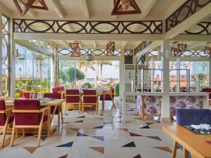 a restaurant with tables and chairs and windows at Rixos Premium Seagate in Sharm El Sheikh